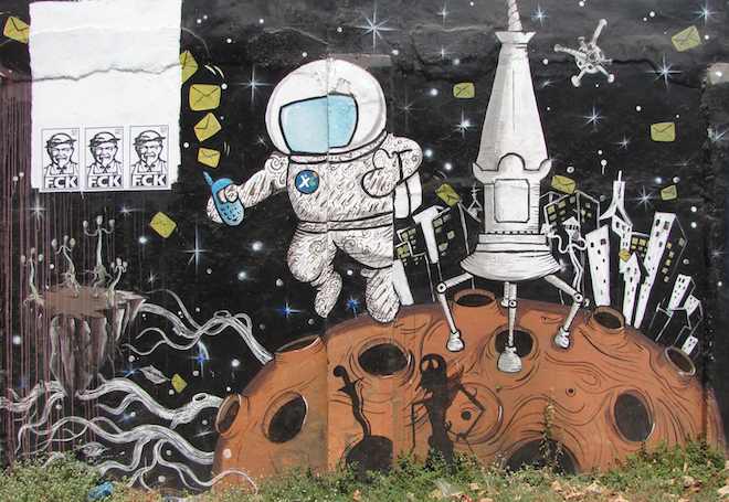 photo of street art of spaceman in space