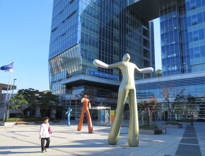large abstract statues of people in front of a building in Seoul